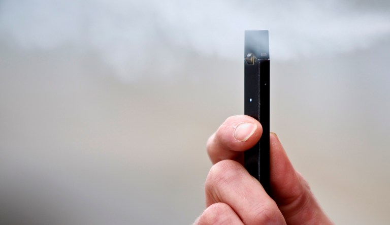 A person puffs from an e-cigarette.