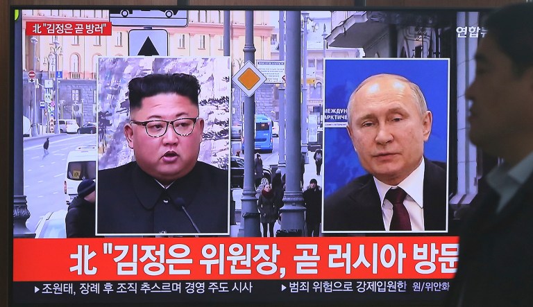A man passes by a TV screen showing images of North Korean leader Kim Jong Un, left, and Russian President Vladimir Putin, right, during a news program at the Seoul Railway Station in Seoul, South Korea.