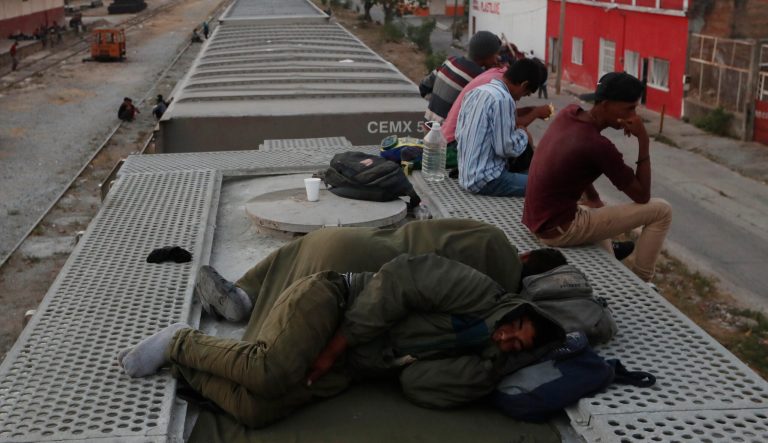 Central American migrants gather on top of a parked freight train, some sleeping, during their journey toward the US-Mexico border, in Arriaga, Chiapas state, Mexico, at sunrise Thursday, April 25, 2019. 