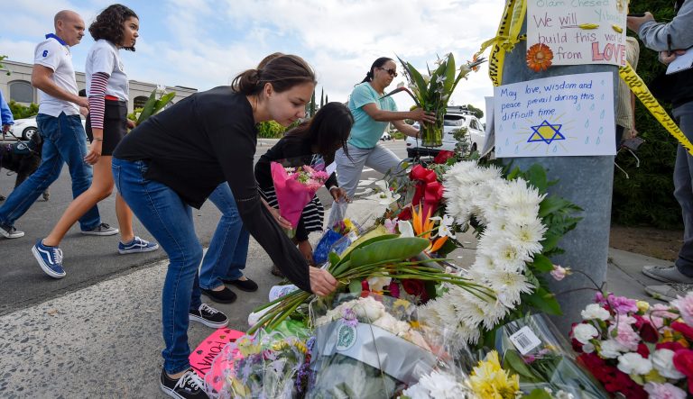 A group of Poway residents bring flowers and cards to a memorial outside of the Chabad of Poway synagogue, Sunday, April 28, 2019, in Poway, Calif. A man opened fire Saturday inside the synagogue near San Diego as worshippers celebrated the last day of a major Jewish holiday. 