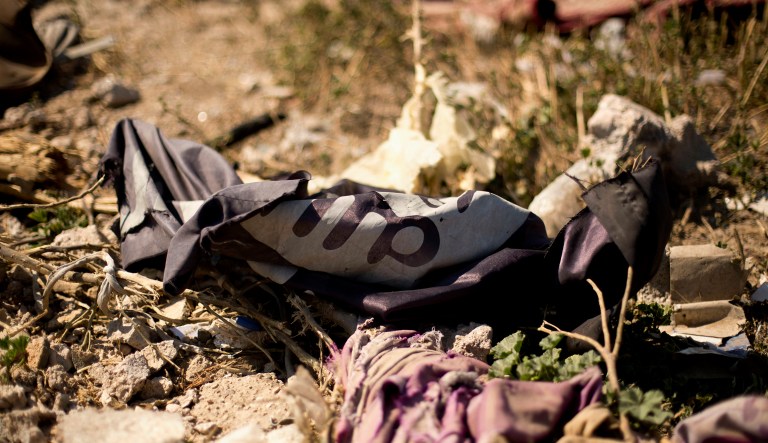 An Islamic State militant flag lies in a tent encampment after U.S.-backed Syrian Democratic Forces fighters took control of Baghouz, Syria.