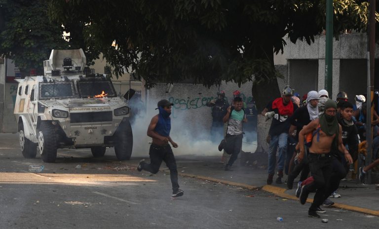 A National Guard armored vehicle drives toward anti-government protesters during clashes in Caracas, Venezuela, Wednesday, May 1, 2019. 