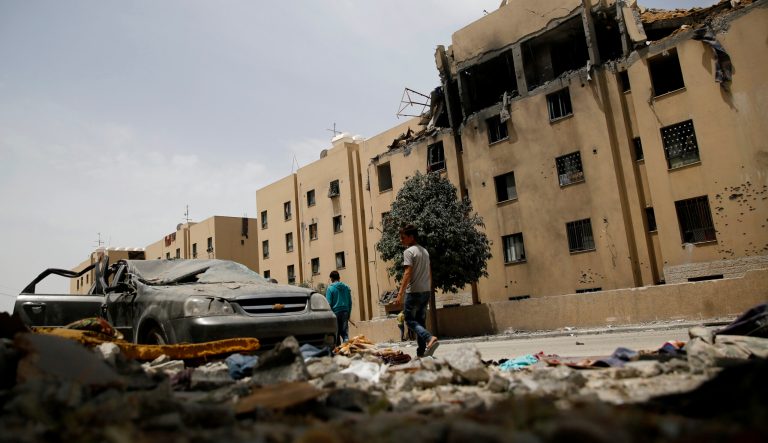 Palestinians walk by a house following a late night Israeli missile strike in town of Beit Lahiya, northern Gaza Strip, Monday, May. 6, 2019. 