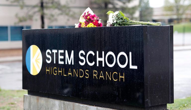 Bouquets of flowers sit on the sign outside the STEM School Highlands Ranch late Wednesday, May 8, 2019, in Highlands Ranch, Colo. 