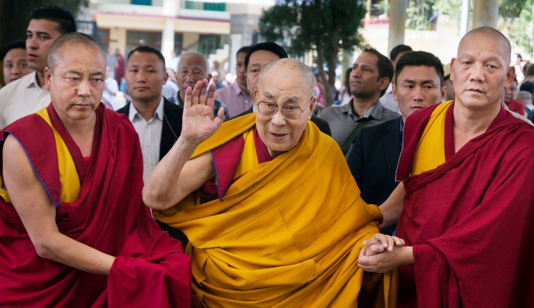 Tibetan Buddhist monks assist their spiritual leader, the Dalai Lama (center), as he arrives to give a religious talk at Tsuglakhang temple in Dharamshala, India.