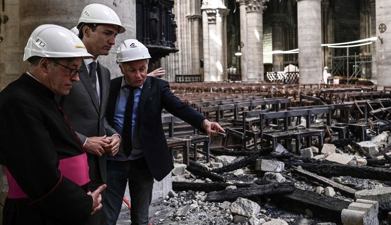 Canadian Prime Minister Justin Trudeau, center, Notre Dame cathedral rector Patrick Chauvet, left, listen to French chief architect of Historical Sites Philippe Villeneuve as they visit Notre Dame de Paris cathedral, Wednesday May 15, 2019 in Paris.