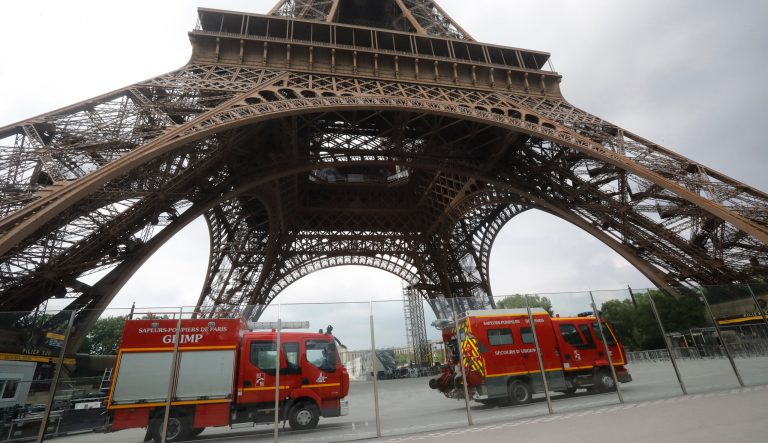 Rescue workers vehicles park just down the Eiffel Tower Monday, May 20, 2019 in Paris. The Eiffel Tower has been closed to visitors after a person has tried to scale it. 