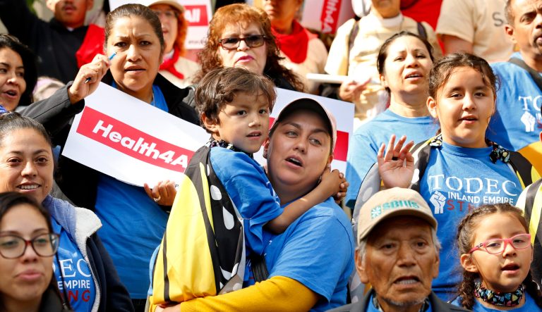 Oralia Sandoval, center, holds her son Benjamin, 6, as she participates in an Immigrants Day of Action rally, Monday, May 20, 2019, in Sacramento, Calif. Gov. Gavin Newsom has proposed offering government-funded health care benefits to immigrant adults ages 19 to 25 who are living in the country illegally. State Sen. Maria Elena Durazo, D-Los Angeles, has proposed a bill to expand that further to include seniors age 65 and older. 
