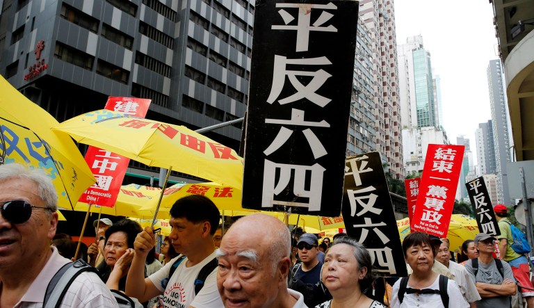 Pro-democracy protesters carry placards with Chinese reads "Vindicate June 4th" and "Put an end to one-party Dictatorship" during a demonstration in Hong Kong on Sunday.