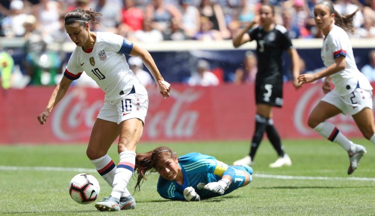 United States forward Carli Lloyd, left, dribbles past Mexico goalkeeper Cecilia Santiago to score a goal during the second half of an international friendly soccer match, Sunday, May 26, 2019, in Harrison, N.J. The U.S. won 3-0. 