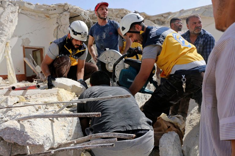 This photo provided by the Syrian Civil Defense White Helmets, which has been authenticated based on its contents and other AP reporting, shows Civil Defense workers searching for victims under the rubble of a destroyed building after an airstrike by Syrian government forces, Maaret al-Numan, a town in south Idlib, Syria, Thursday, May 30, 2019. Rescue workers and activists say at least five, including three from the same family, have been killed in Syria's last rebel stronghold when warplanes targeted the building they live in, leveling it. (Syrian Civil Defense White Helmets via AP)