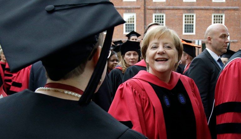 German Chancellor Angela Merkel greets graduating Harvard students as she walks in a procession though Harvard Yard at the start of Harvard University commencement exercises, Thursday, May 30, 2019, in Cambridge, Mass.