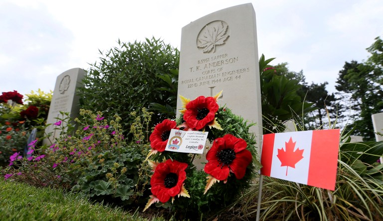 Flowers and a flag adorn a grave of a Canadian World War II soldier at the Beny-sur-Mer Canadian War Cemetery in Reviers, Normandy, France, Wednesday, June 5, 2019.