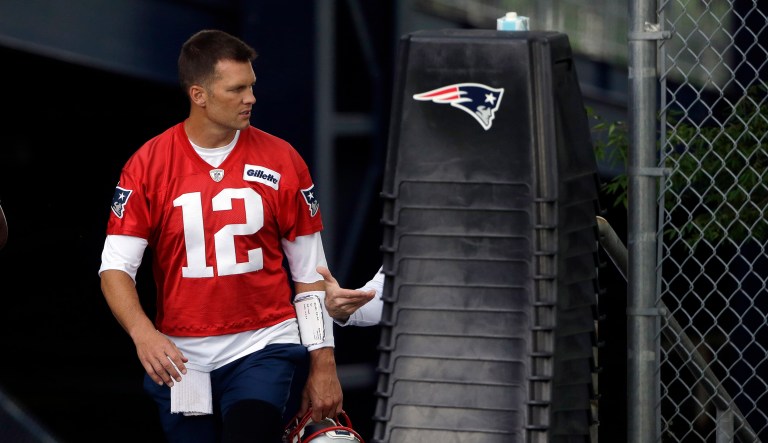 New England Patriots quarterback Tom Brady steps on the field before the start of an NFL football training camp in Foxborough, Massachusetts.