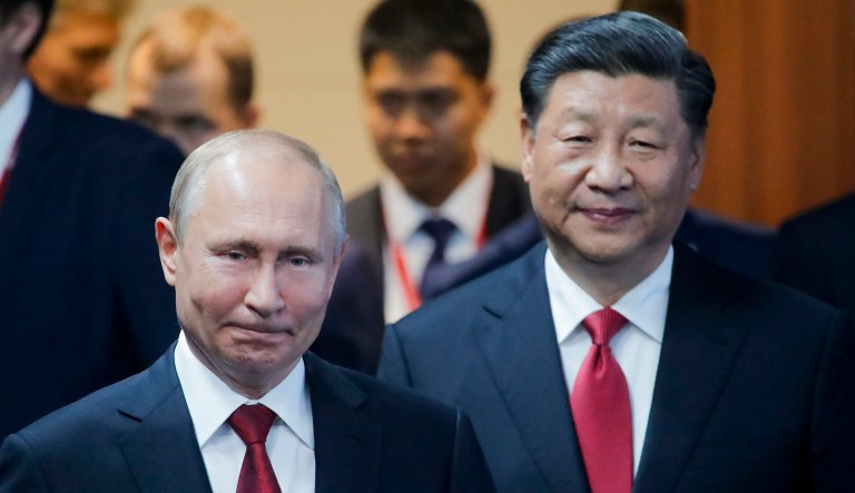 Russian President Vladimir Putin, left, and Chinese President Xi Jinping arrive at an event.