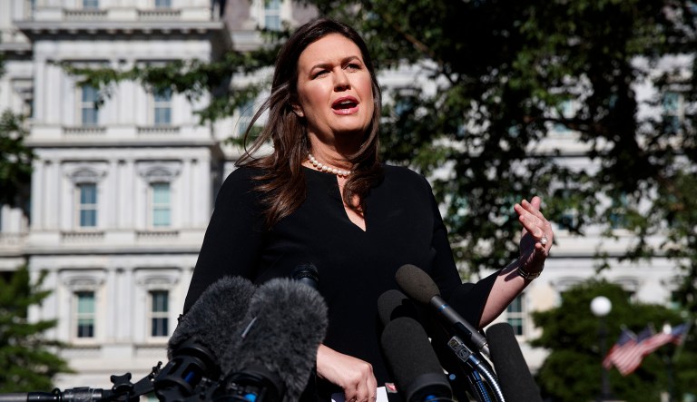 White House press secretary Sarah Sanders talks with reporters outside the White House in Washington. 