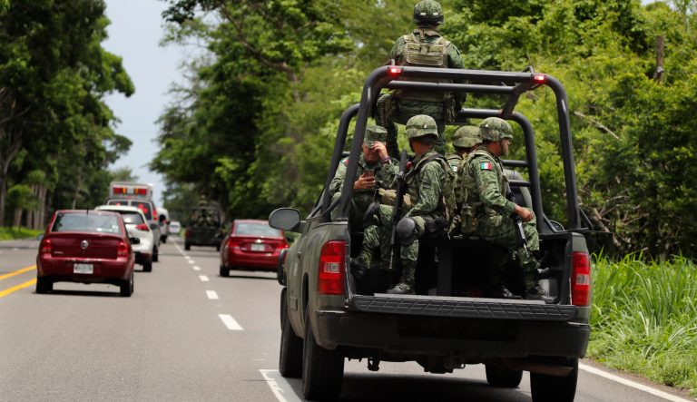 Mexican marines ride in the back of a pick up truck as they escort the caravan carrying Mexican Minister of Defense in Tapachula, Mexico, Tuesday, June 11, 2019. Mexican officials say they are beginning deployment of 6,000 National Guard troops for immigration enforcement, an accelerated commitment made as part of an agreement with the United States last week to head off threatened U.S. tariffs on imports from Mexico. 
