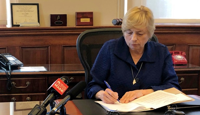 Maine Democratic Gov. Janet Mills signs a bill in her office in Augusta, Maine.