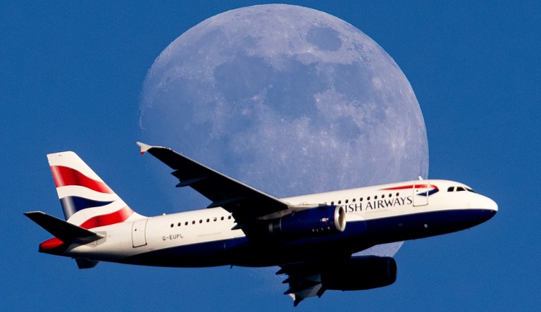 The moon rises as a British Airways aircraft flies on its way to the airport in Frankfurt, Germany, Thursday, June 13, 2019. 