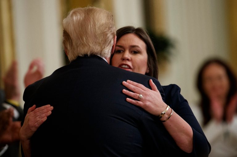 White House press secretary Sarah Sanders hugs President Donald Trump.