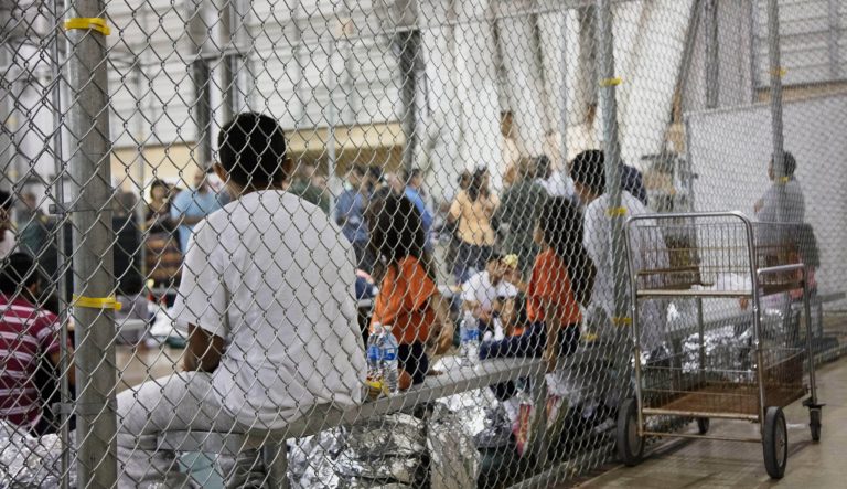 In this June 17, 2018, photo, provided by U.S. Customs and Border Protection, people who have been taken into custody related to cases of illegal entry into the United States, sit in one of the cages at a facility in McAllen, Texas. 