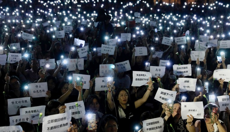 Hundreds of mothers holding placards, some of which read "If we lose the young generation, what's left of Hong Kong", and lit smartphones protest against the amendments to the extradition law in Hong Kong on Friday, June 14, 2019. Calm appeared to have returned to Hong Kong after days of protests by students and human rights activists opposed to a bill that would allow suspects to be tried in mainland Chinese courts.