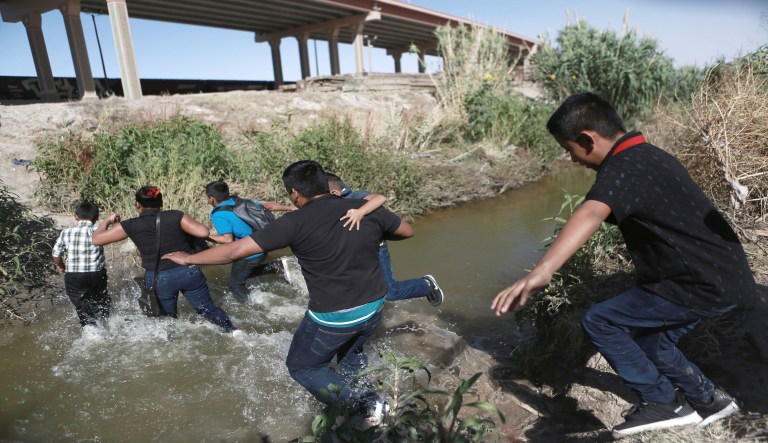 Migrants scramble across the Rio Bravo to surrender to the American authorities, on the U.S.-Mexico border between Ciudad Juarez and El Paso, Saturday, June 15, 2019. 