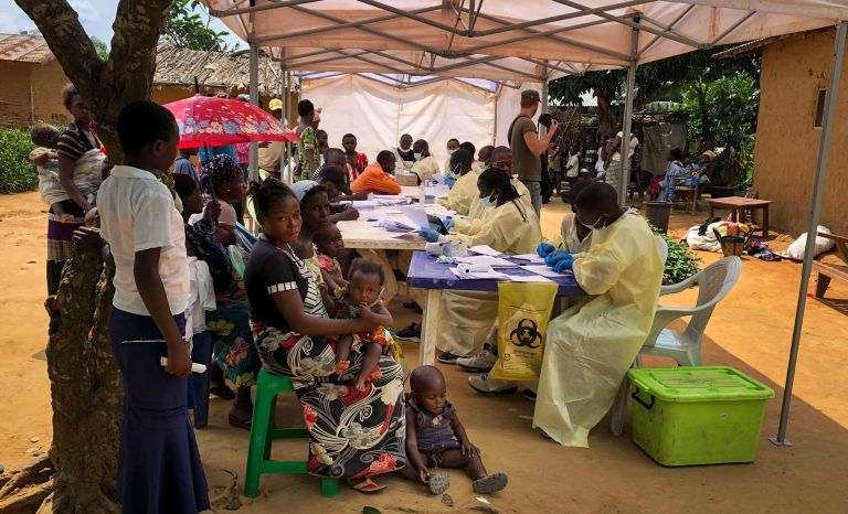 A woman and her children wait to receive Ebola vaccinations, in the village of Mabalako, in eastern Congo Monday, June 17, 2019.