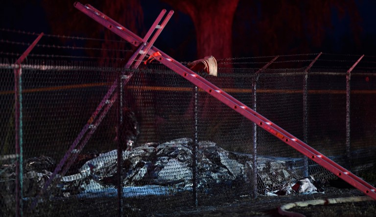 Remnants of an aircraft carrying nine people lies on the ground near a fence that surrounds Dillingham Airfield in Mokuleia, just off Farrington Highway, Friday, June 21, 2019. Nine people on board the twin engine aircraft died Friday night in a crash on Oahu's North Shore, officials said.