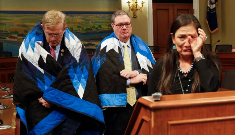 Rep. Deb Haaland, D-N.M., cries while speaking as Rep. Denny Heck, D-Wash., and Rep. Paul Cook, R-Calif., listen during a news conference Tuesday on Capitol Hill in Washington. Advocates for Native Americans called for Congress to revoke the Medals of Honor given to the U.S. soldiers who participated in the Wounded Knee massacre.