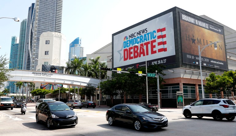 Cars pass by a billboard advertising the Democratic Presidential Debates across from the Knight Concert Hall at the Adrienne Arsht Center for the Performing Arts of Miami-Dade County in Miami.