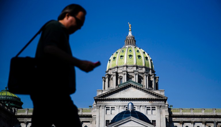A pedestrian walks by the state Capitol in Harrisburg, Pennsylvania.