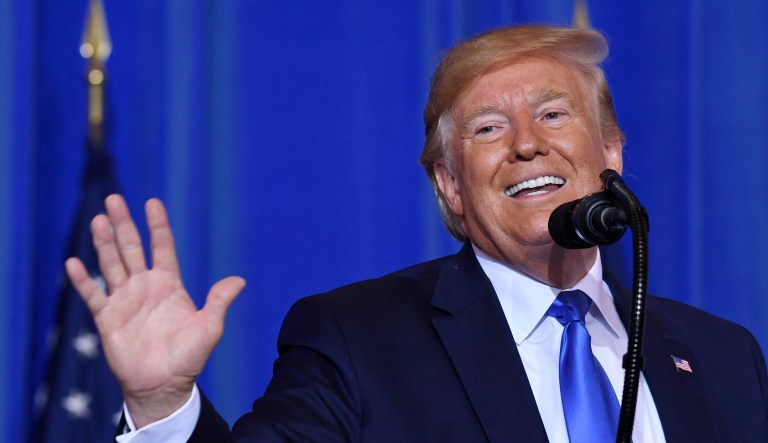 President Trump smiles while speaking during a press conference.