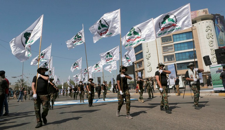 Iraqi Popular Mobilization Forces march as they hold Popular Mobilization flags in Baghdad, Iraq.