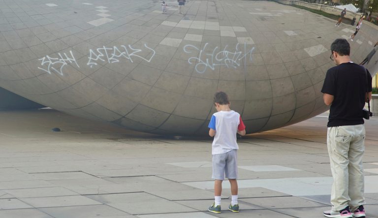 Graffiti mars the popular giant metallic sculpture known as "The Bean," Tuesday, July 2, 2019, in Chicago. 
