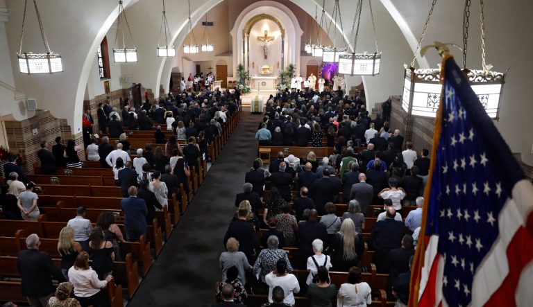 Mourners stand during the funeral Mass for Detective Luis Alvarez, at Immaculate Conception Church, in the Queens borough of New York, Wednesday, July 3, 2019. 