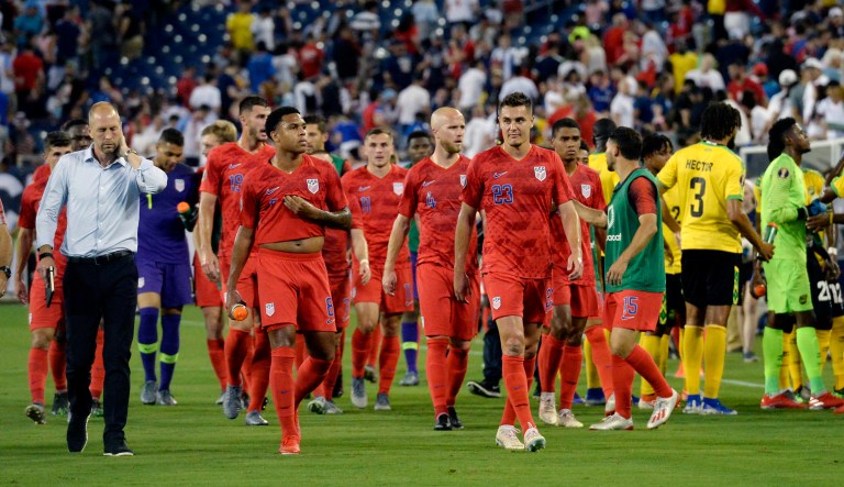 United States National Team head coach Gregg Berhalter, left, walks off the pitch with players during a weather delay.