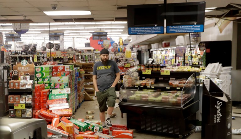 A worker steps over merchandise that is scattered on the floor of a Albertson's grocery store Saturday, July 6, 2019 following a earthquake in Ridgecrest, Calif. The Friday evening quake with a magnitude of about 7.1 jolted much of California.