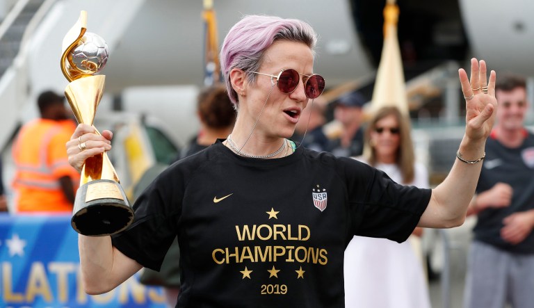 Megan Rapinoe holds the Women's World Cup trophy after she and other members of the U.S. women's national soccer team, winners of a fourth Women's World Cup, celebrated after arriving at Newark Liberty International Airport in Newark, New Jersey.