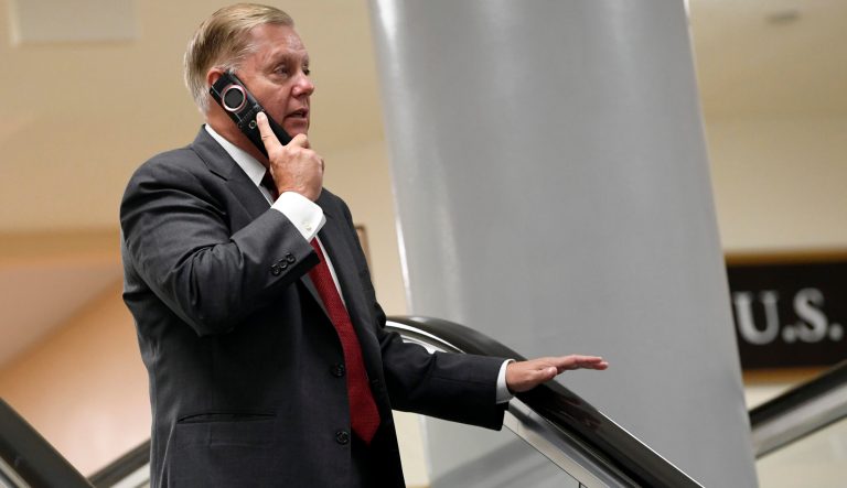 Sen. Lindsey Graham, R-S.C., talks on the phone as he rides the escalator on Capitol Hill in Washington, Wednesday, July 10, 2019, as he heads to a briefing on election security. 