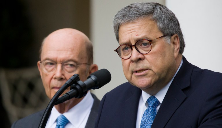 Attorney General William Barr, right, accompanied by Commerce Secretary Wilbur Ross, speaks in Washington. 