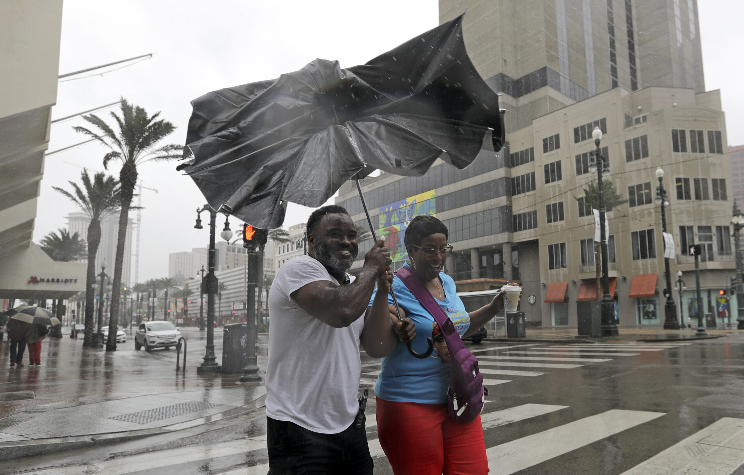 Karon Hill, left, and Celeste Cruz battle the wind and rain from Barry as it nears landfall Saturday in New Orleans.