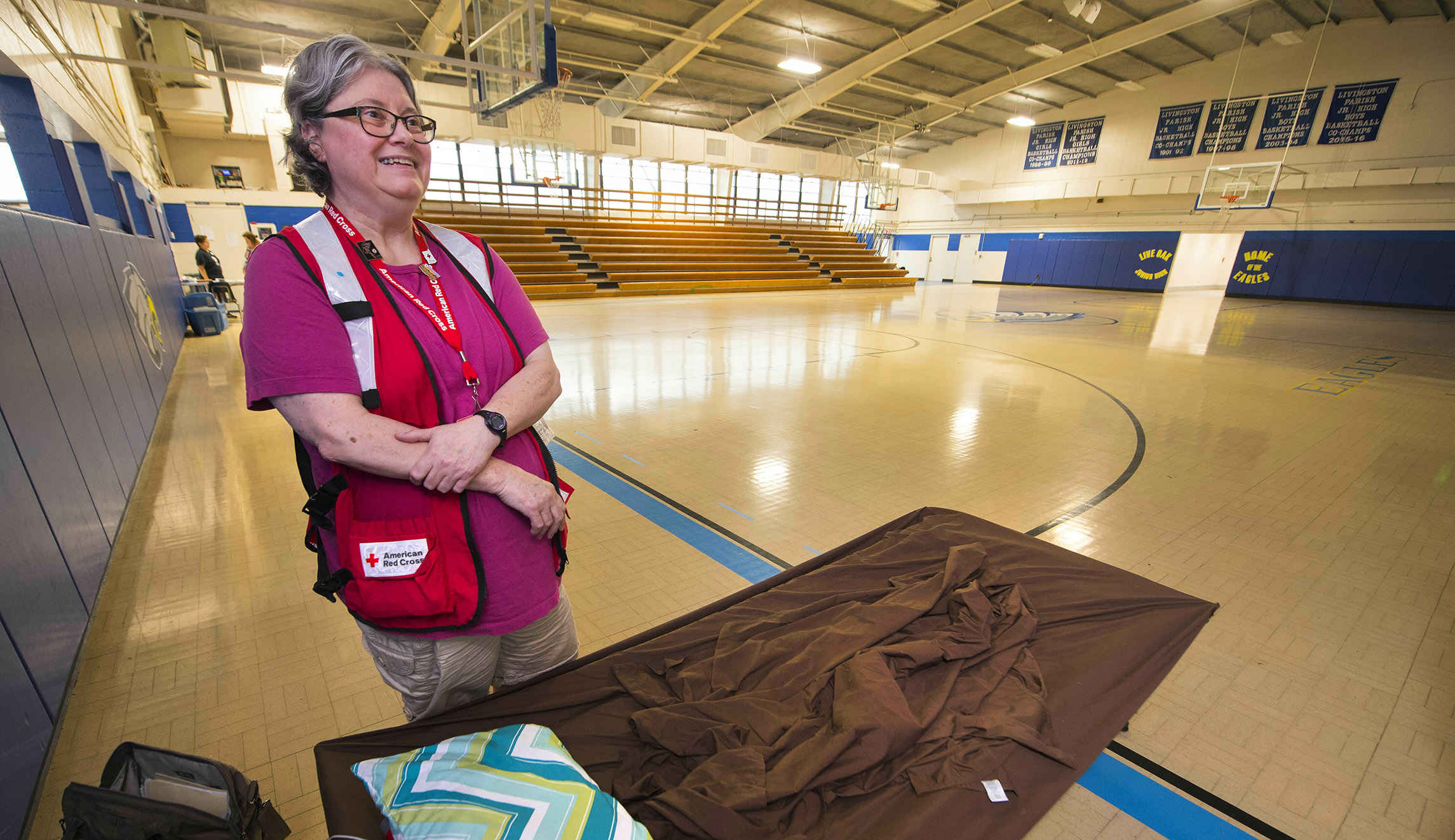 Richmond, New Hampshire's Alicia Drew, a volunteer with the American Red Cross, talks next to her cot inside Live Oak Junior High School's gymnasium, at a shelter there that she was managing for the Livingston Parish Office of Emergency Preparedness on Saturday.