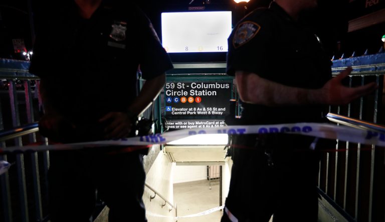 New York City police officers stand guard at a closed subway station during a power outage Saturday, July 13, 2019, in New York.  
