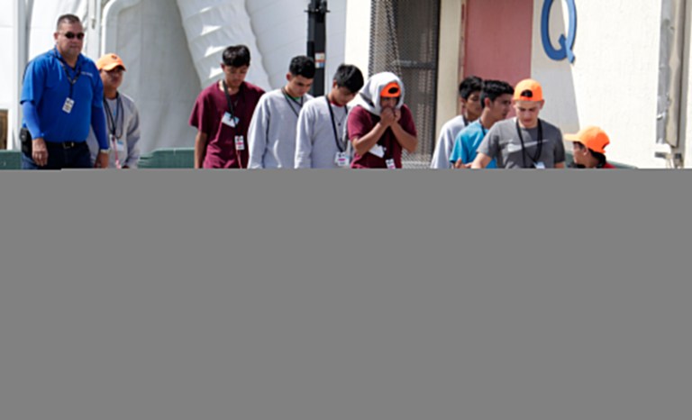 Migrant children walk on the grounds of the Homestead Temporary Shelter for Unaccompanied Children, Monday, July 15, 2019, in Homestead, Florida. 
