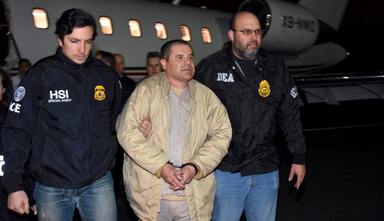 In this Jan. 19, 2017 photo provided by U.S. law enforcement, authorities escort Joaquin "El Chapo" Guzman, center, from a plane to a waiting caravan of SUVs at Long Island MacArthur Airport, in Ronkonkoma, N.Y. 