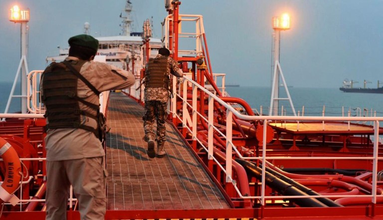 In this Sunday, July 21, 2019 photo, two armed members of Iran's Revolutionary Guard inspect the British-flagged oil tanker Stena Impero, which was seized in the Strait of Hormuz on Friday by the Guard, in the Iranian port of Bandar Abbas. 