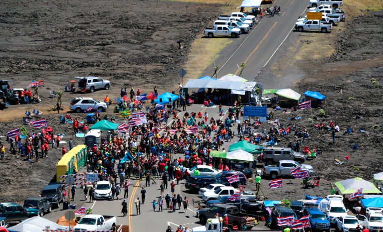 In this Sunday, July 21, 2019, photo provided by the Hawaii Department of Land and Natural Resources, protesters block a road to the summit of Mauna Kea in Hawaii. 