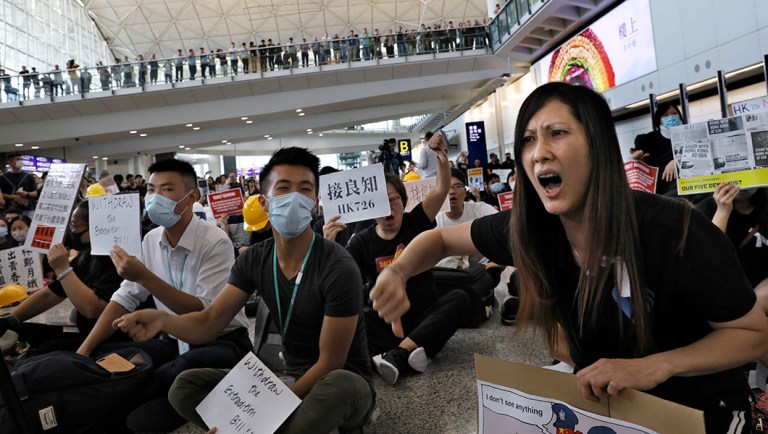 Demonstrators shout slogans during a protest at Hong Kong International Airport.
