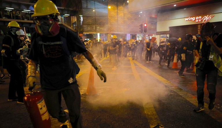 Protesters run away from tear gas smoke during a protest in Hong Kong.
